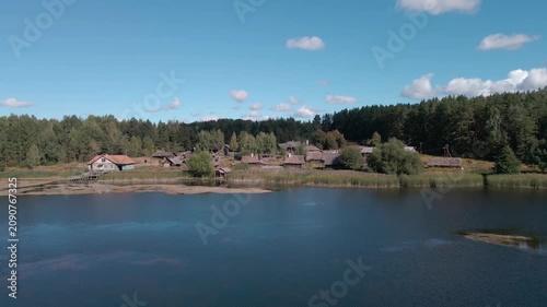 Aerial Drone Flight Over Historic Wooden Village by Lake Surrounded by Forest