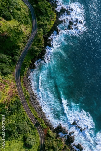 Aerial top view of a scenic coastal road next to the turquoise ocean and rocks.