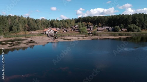 Aerial Drone Flight Over Historic Wooden Village by Lake Surrounded by Forest