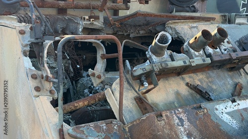Konstfotografi Burnt out roof and open hatches of a destroyed armored personnel carrier, showing heavily rusted components and interior debris