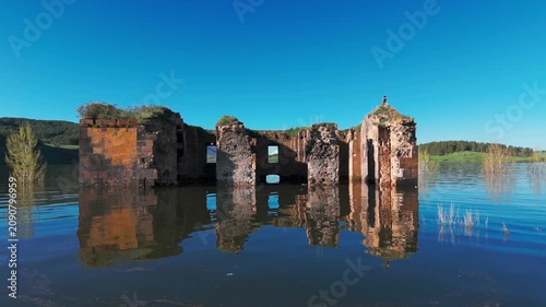 Aerial shot Saint Paul and Peter (Surb Pogos Petros) Church in Aparan Reservoir, Armenia. Ancient Armenian church partially submerged in the blue waters of Aparan Reservoir, Armenia. Historic medieval
