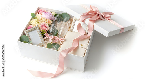 Elegant white gift box with pink ribbon and wedding essentials