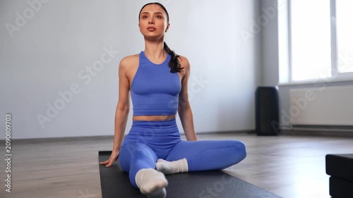 Portrait of active sporty fit woman doing warming up, practicing one-legged forward bend yoga exercise on fitness mat, strengthening leg and spine muscles during workout in health club.