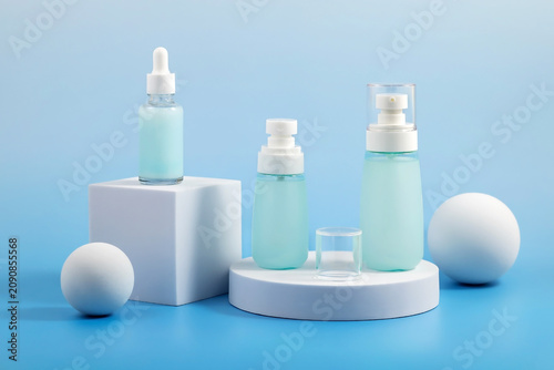 Skincare Product Collection on Blue Display. Skincare bottles arranged on geometric platforms with a blue background.