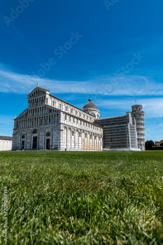 Картината върху платно PISA ITALY APRIL 5 2026: Low-angle view of the Pisa Cathedral and the Leaning Tower above a green lawn