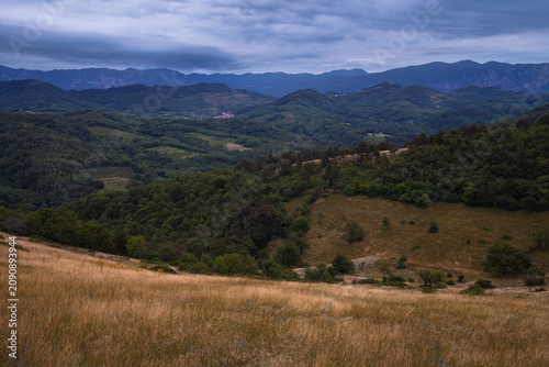 Scenic countryside in Slovenia featuring rolling hills, mountain ridges and moody weather. Peaceful landscape with ideal panoramic views.