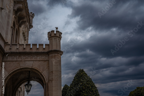 Entrance tower of Miramare Castle beneath dramatic storm clouds overlooking the Adriatic coast near Trieste, Italy.