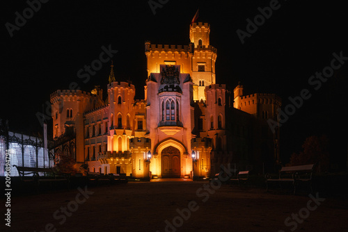Illuminated Hluboka nad Vltavou Castle at night in South Bohemia, Czech Republic. Neo-Gothic architecture glowing against the dark sky.