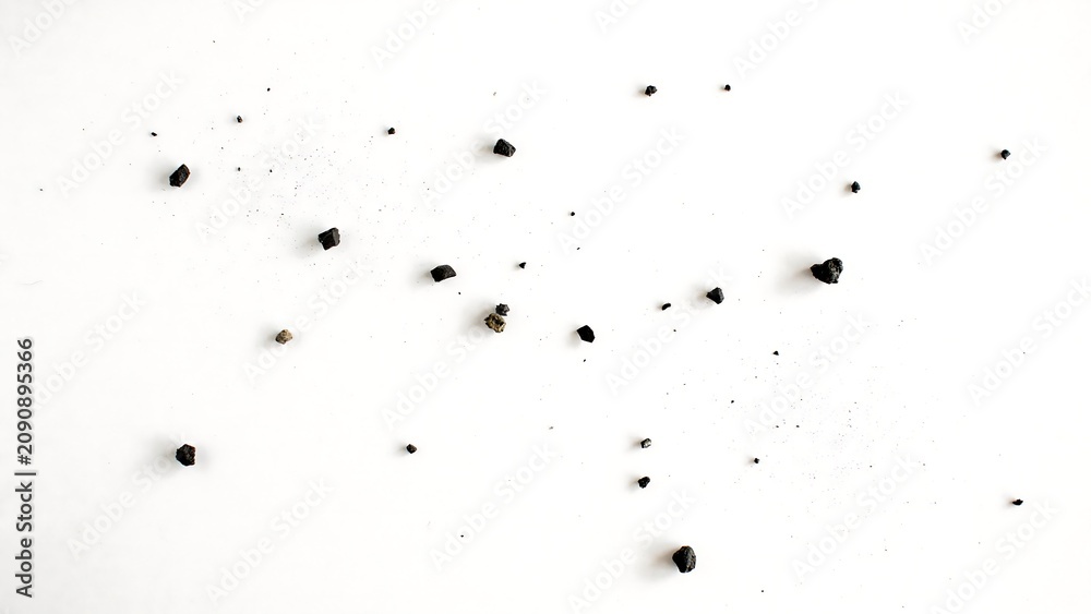 Obraz premium Scattered black coffee beans isolated on clean white background with scattered
