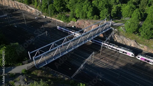 Aerial drone view of Linnunlaulu Bridge by Töölönlahti in Helsinki, Finland, crossing over the railway tracks.