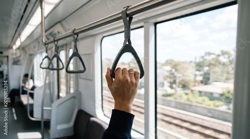 Commuter Holding Safety Handle in Metro Train Interior