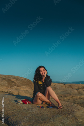 Woman Writing in Journal on Rocks at Sunset by the sea – Peaceful Reflexion Moment