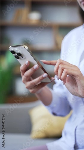 Vertical close up woman hands using smartphone, swiping, scrolling, surfing in social media, reading text message, chatting with friend, browsing on internet. Female shopping online at home. 