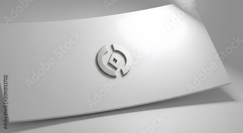 Modern metallic circular logo emblem featuring a diamond shape center piece displayed on a clean white curved studio surface