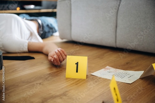 Foto Forensic investigation scene depicting a lifeless body on the floor with evidenc