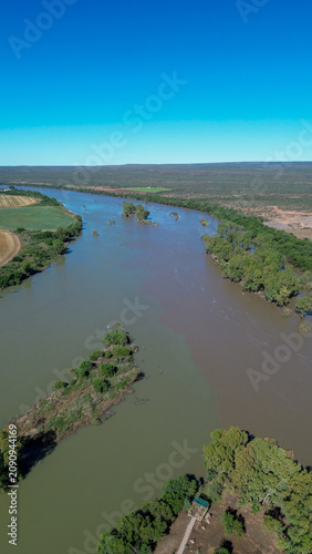 Aerial view of the confluence of the Vaal river and the Orange river south of the town of Douglas, Northern Cape, where brown and green river water merge.  Vertical image