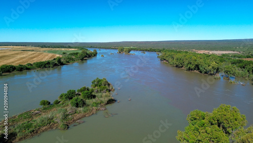 Aerial view of the confluence of the Vaal river and the Orange river south of the town of Douglas, Northern Cape, where brown and green river water merge.  Vertical image