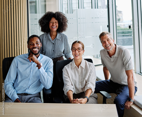 Portrait of a group of young and business people having a meeting in the office. Teamwork and success concept