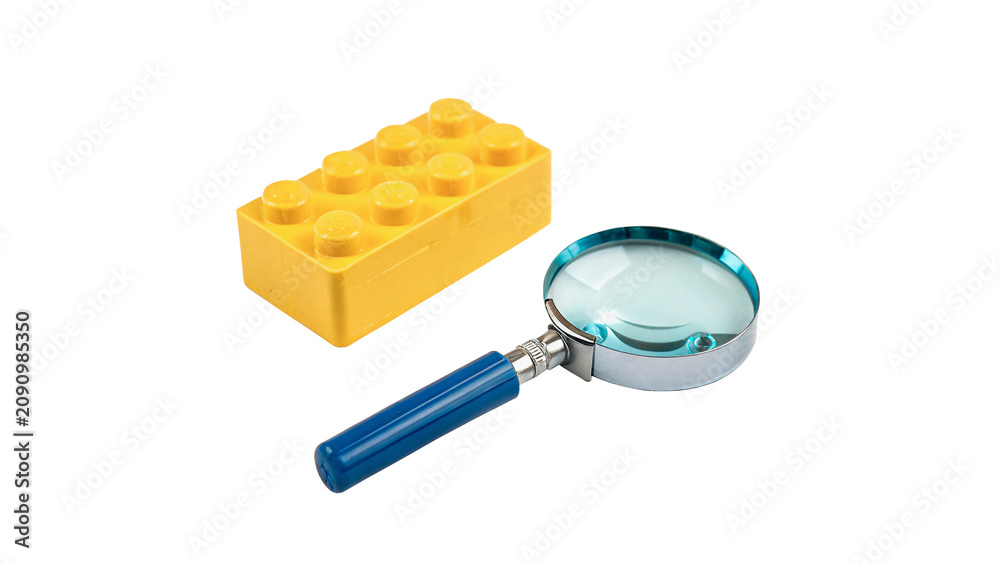 Obraz premium Yellow plastic building block lego brick with magnifier isolated on transparent background