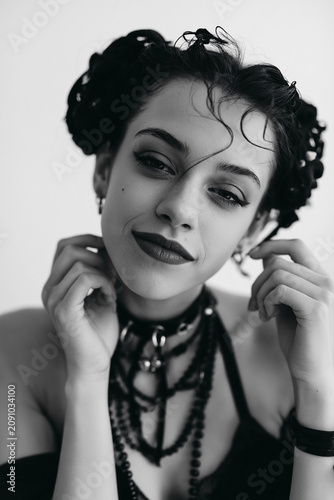 Portrait of woman with dramatic makeup and layered necklaces in black and white close up