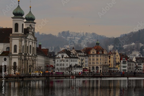 Tableau sur toile Church and old town waterfront reflection on Reuss river in Lucerne Switzerland