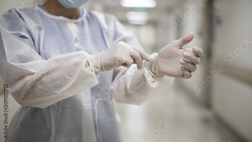 Healthcare Professional Putting On Sterile Protective Gloves