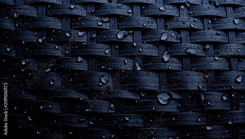 Dark woven texture pattern adorned with fresh rain water droplets