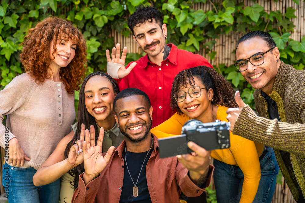 Fototapeta premium Diverse smiling people taking a group selfie video together