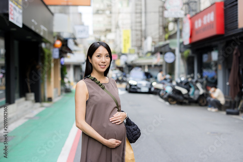 Happy pregnant woman walking outside