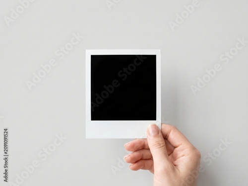Hand holding blank photo frame