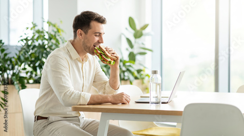 Businessman enjoying a sandwich during a break in the office