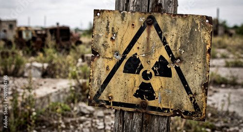 Old rusty radiation warning sign in abandoned post apocalyptic wasteland