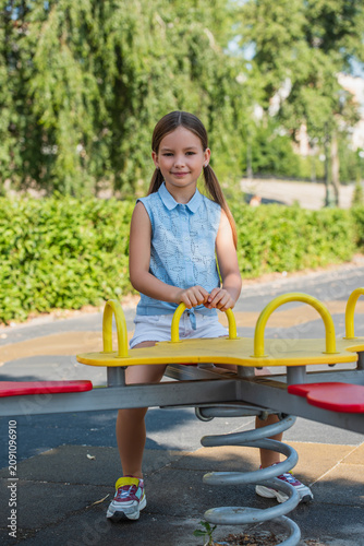 Obraz na płótnie Little cute girl in a sunlit park filled with laughter and playful adventures