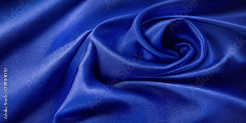 Fényképezés A luxurious blue silk fabric is artfully draped, creating elegant folds and a mesmerizing spiral pattern that conveys a sense of opulence and sophistication
