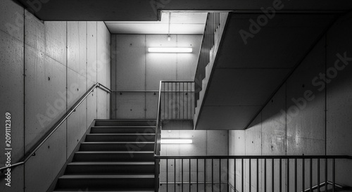 Monochrome Stairwell Interior with Illuminating Lights and Concrete Walls