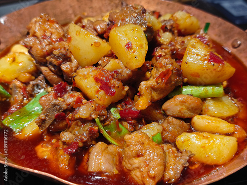 A delicious plate of Chinese big plate chicken features tender chicken pieces, soft potatoes, and chili peppers in savory sauce