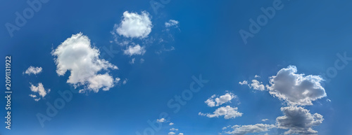 A few cumulus clouds obscure the sky, creating a window of blue sky. A bright summer sky in fine weather.