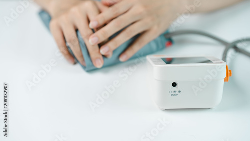Konstfotografi Close-up of an adult measuring blood pressure with a digital monitor at home