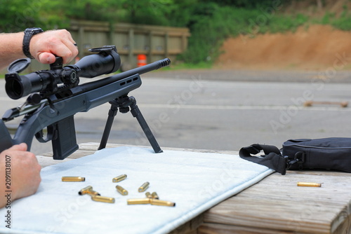 Принти на полотні Man adjusts scope while shooting targets at the rifle range
