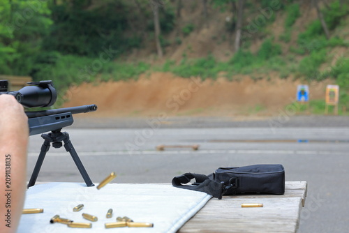 Bild auf Leinwand Man ejects spent shell from his rifle at the gun range