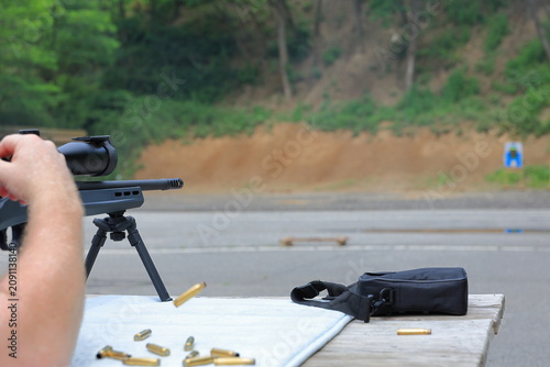Obraz na plátně Man ejects spent shell from his rifle at the gun range