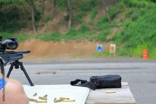 Canvas Print Man lines up targets while shooting his rifle at the gun range