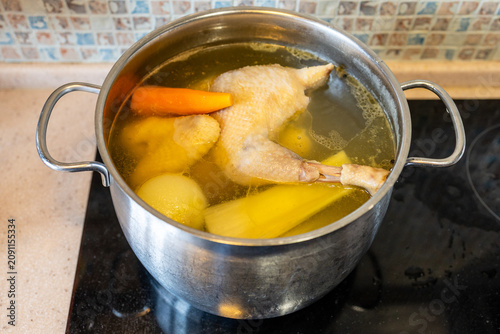 chicken broth is cooking with vegetables in pot