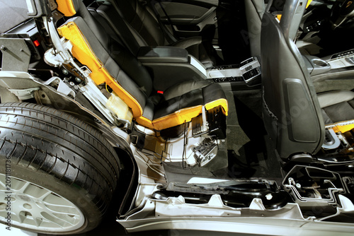 A car interior cross-section showing seat structure and mechanical components on display