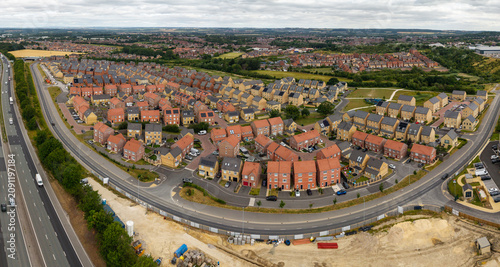 Aerial view of a new UK village in countryside with brand new build houses