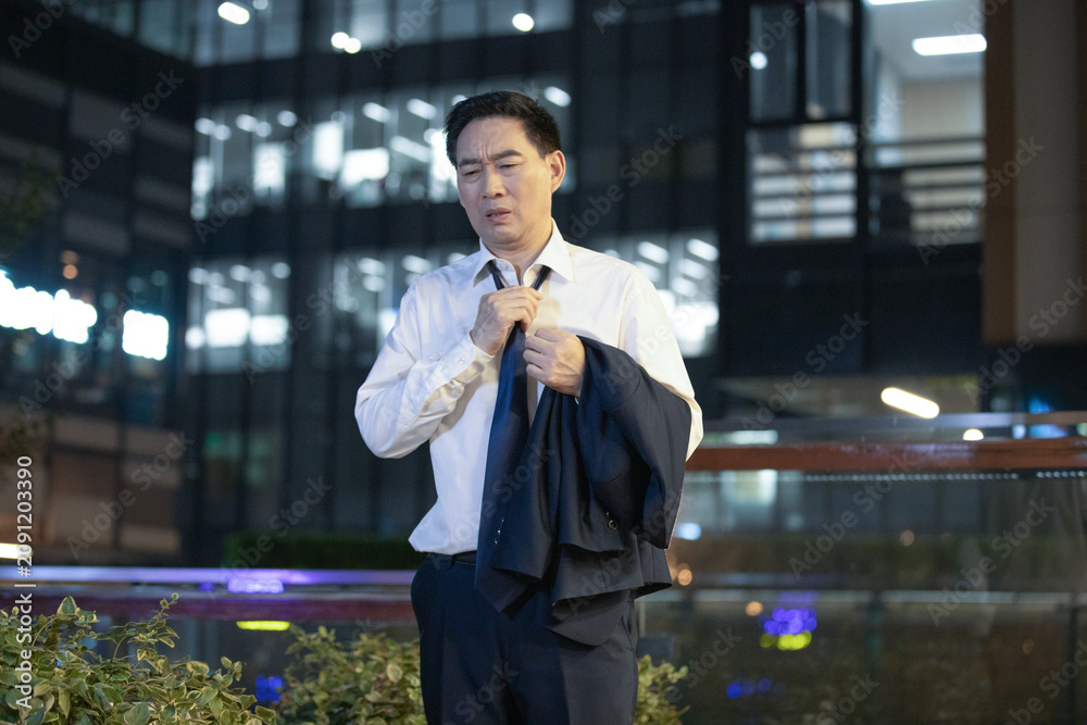 Ταπετσαρία Exhausted businessman loosening tie outside office building at night