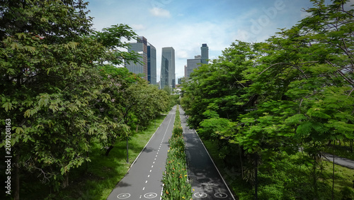 A stunning view of Benjakitti Forest Park—a green oasis in Bangkok, Thailand—featuring lush greenery and paths for cycling or strolling that lead toward the modern city skyline. 