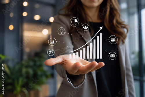 Businesswoman holding rising growth chart with business and marketing icons