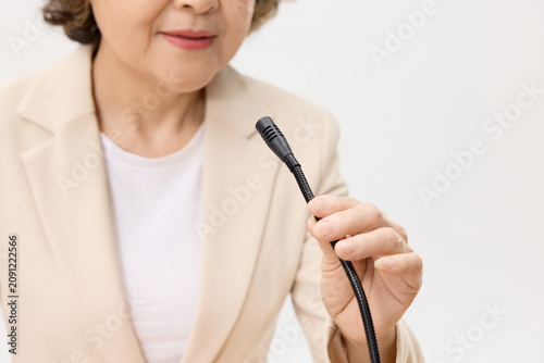 Фотография Senior woman holding microphone during speech or interview