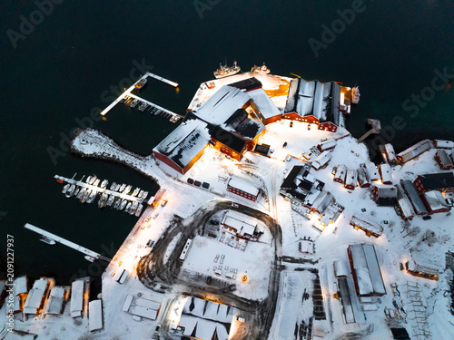 Aerial winter harbor with snow covered buildings and docks